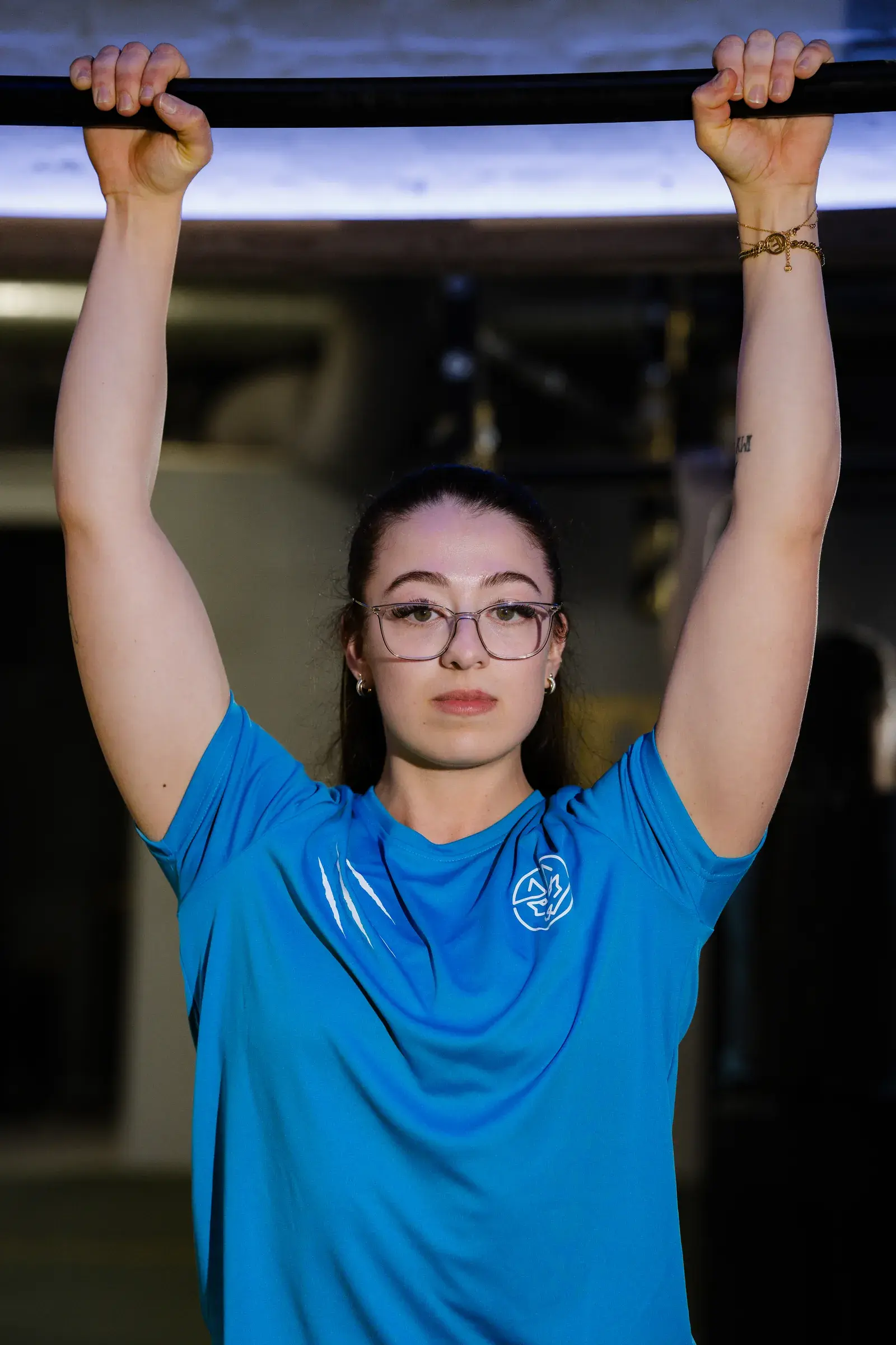 Een sporter hangt gecontroleerd aan de pull-upstang