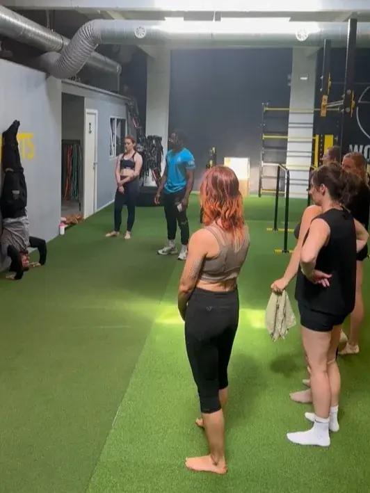 A coach explains a move during a handstand workshop in the hall
